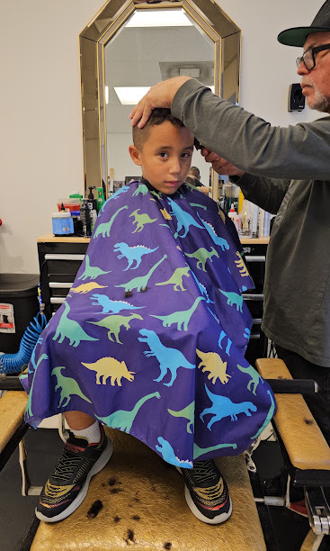 Young client getting a haircut in the shop